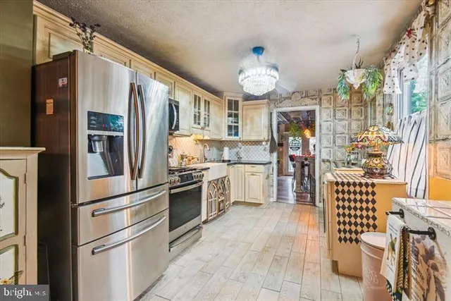 a kitchen with stainless steel appliances granite countertop a refrigerator and a stove top oven