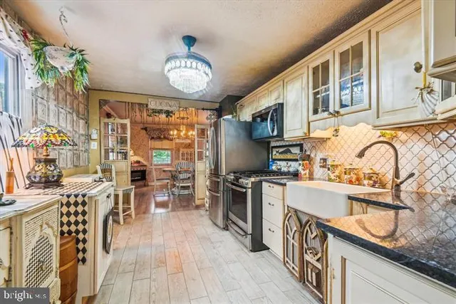 a kitchen with stainless steel appliances granite countertop a stove oven a sink dishwasher and cabinets with wooden floor