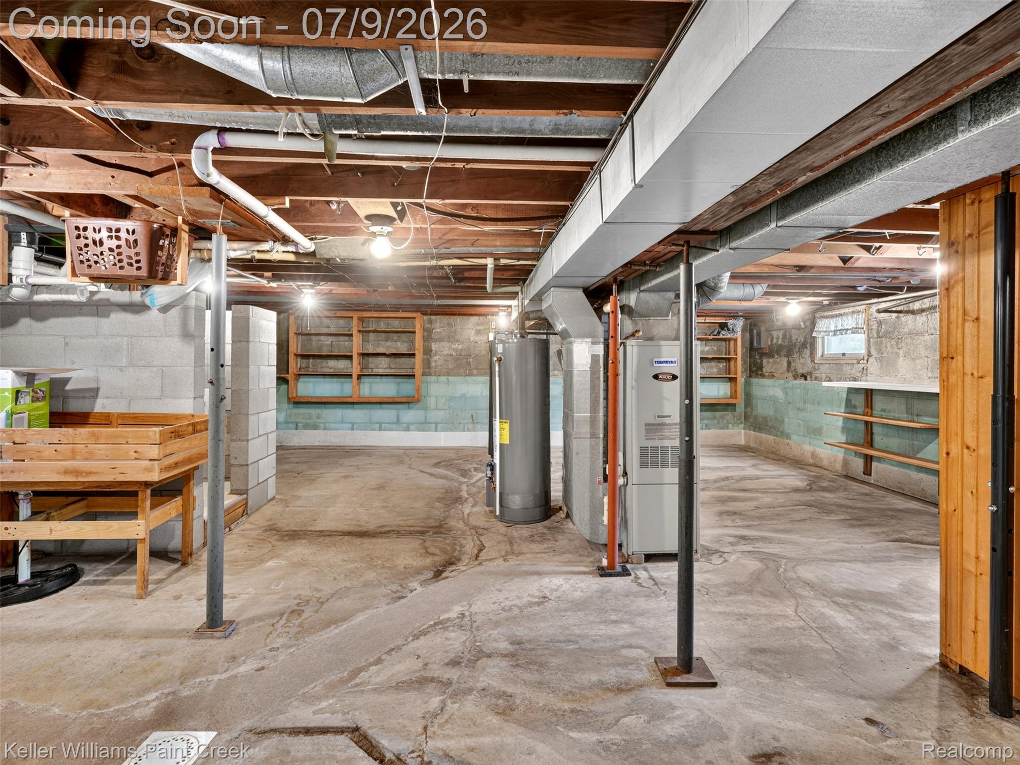 204 Russell Road Kawkawlin, MI 48631 - Photo 52 of 82 Unfinished basement featuring exposed wood joists, concrete block walls, and a concrete floor