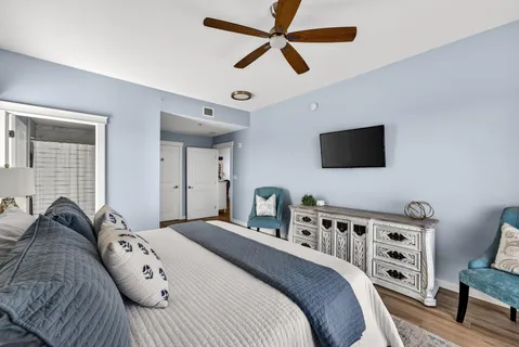 a bedroom with a bed a flat screen tv and a couch