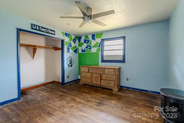 an empty room with a window and a ceiling fan