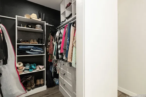 a view of walk in closet with clothes and shoes