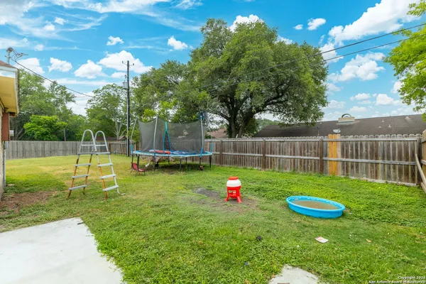 a backyard of a house with table and chairs