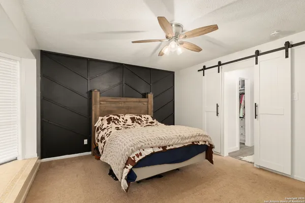 a bedroom with a bed and a ceiling fan