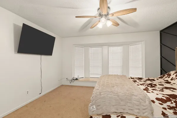 a large bedroom with a bed and a flat screen tv