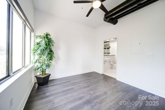 a view of a hallway with wooden floor and a potted plant