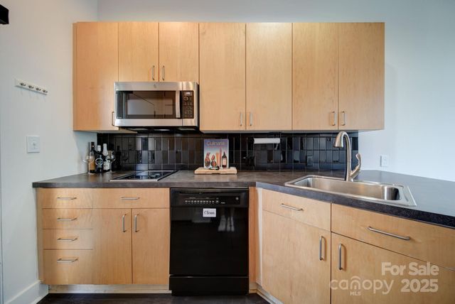 a kitchen with stainless steel appliances granite countertop a sink a stove and a microwave