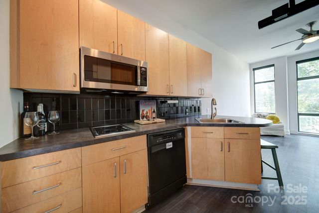 a kitchen with stainless steel appliances granite countertop a sink a stove and cabinets