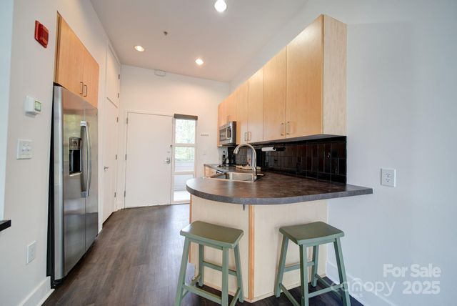 a kitchen with stainless steel appliances a microwave a stove and white cabinets