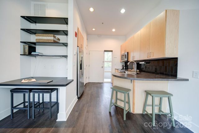 a kitchen with stainless steel appliances a stove a refrigerator and a dining table