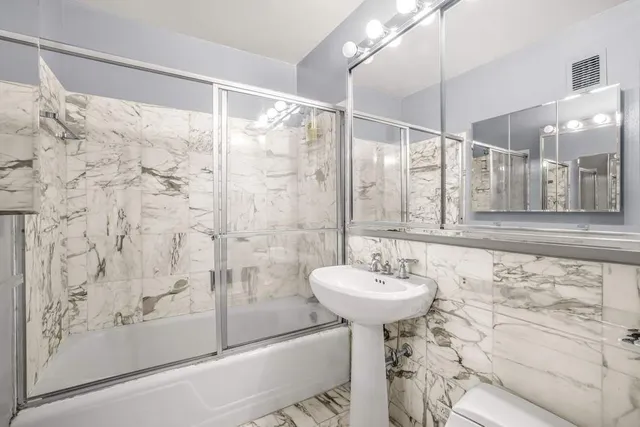 a large bedroom with a large bed couch and a view of kitchen