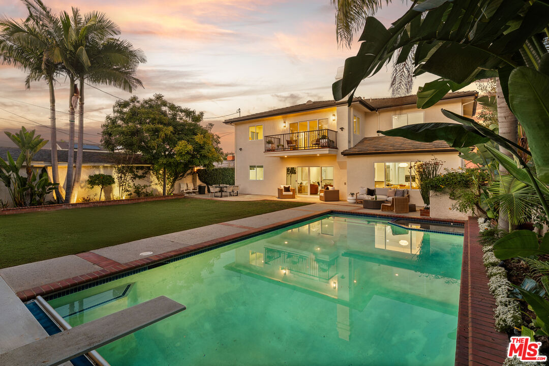 7825 Cowan Avenue Los Angeles, CA 90045 - Photo 1 of 33 a view of a swimming pool with a lawn chairs under palm trees