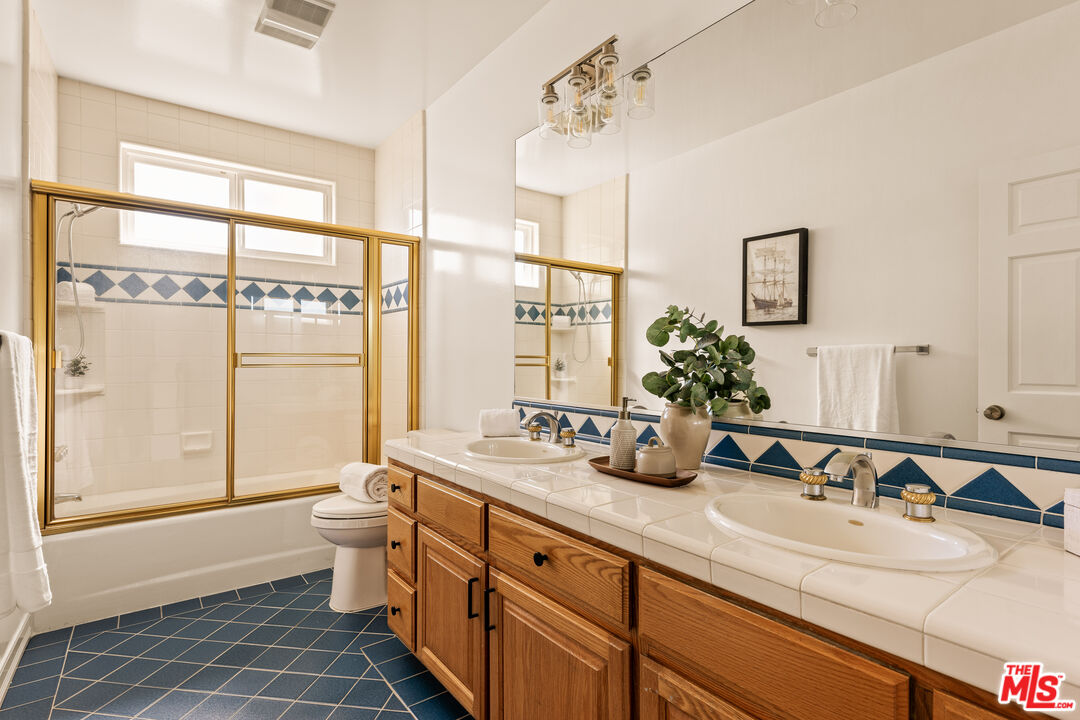 7825 Cowan Avenue Los Angeles, CA 90045 - Photo 23 of 33 a bathroom with a double vanity sink large mirror and a shower
