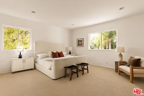 a bathroom with a tub sink vanity and a large mirror