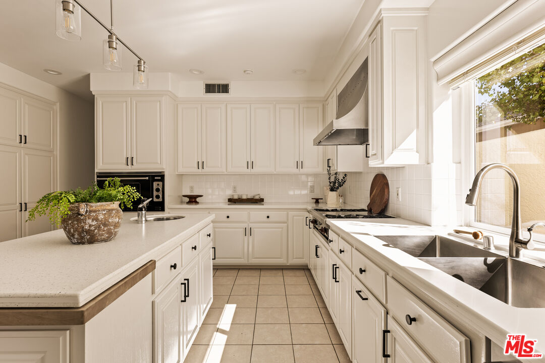 7825 Cowan Avenue Los Angeles, CA 90045 - Photo 10 of 33 a kitchen with cabinets appliances a sink and a window