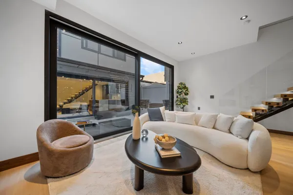 a living room with stainless steel appliances furniture and a kitchen view