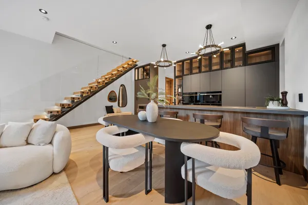 a kitchen with a table chairs a stove and a dining table