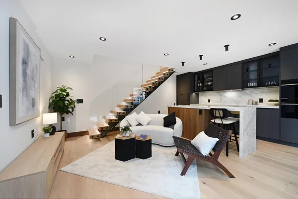 a kitchen with stainless steel appliances granite countertop a refrigerator a stove and a sink with wooden floor