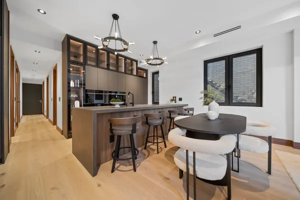 a kitchen with a dining table chairs stainless steel appliances and cabinets