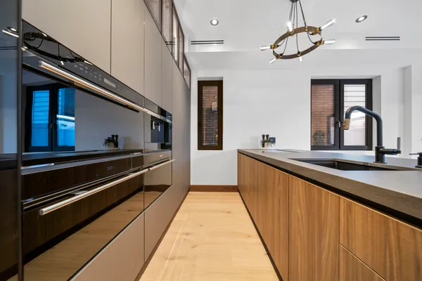 a large kitchen with stainless steel appliances granite countertop lots of counter top space and wooden floor