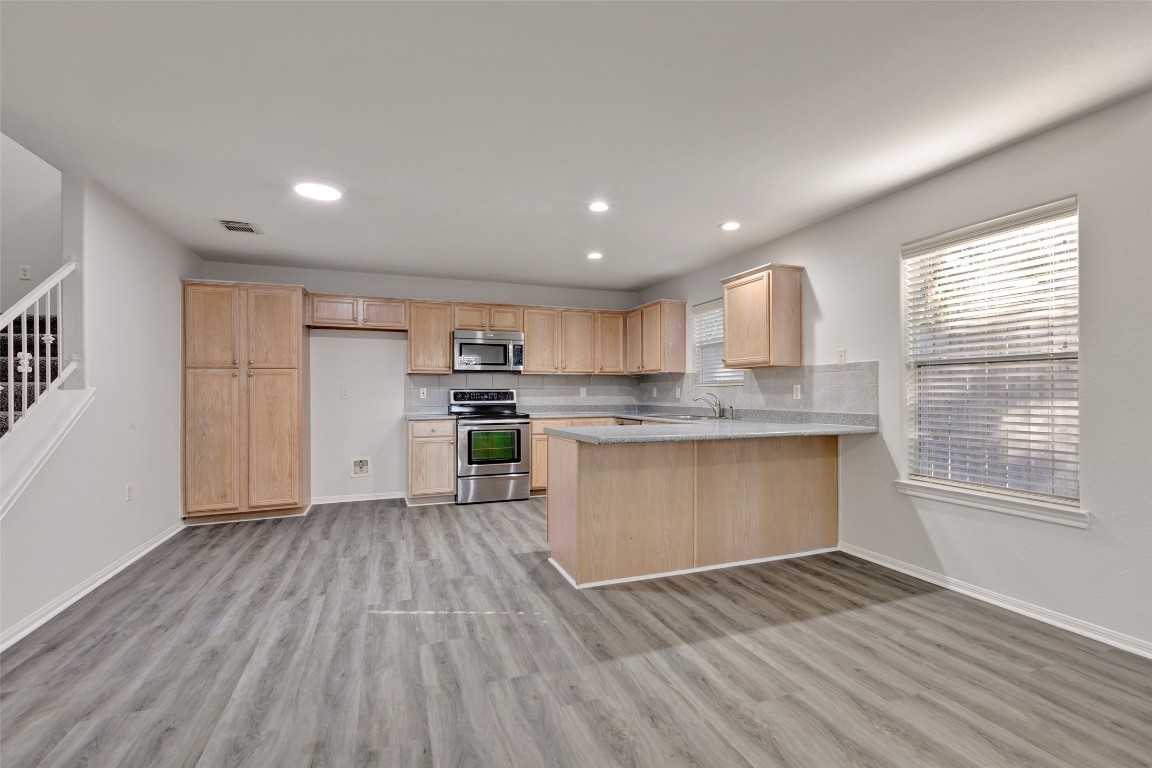 770 Hunt Road, Unit 212 Baytown, TX 77521 - Photo 14 of 40 a kitchen with stainless steel appliances granite countertop a stove top oven a sink dishwasher and white cabinets with wooden floor