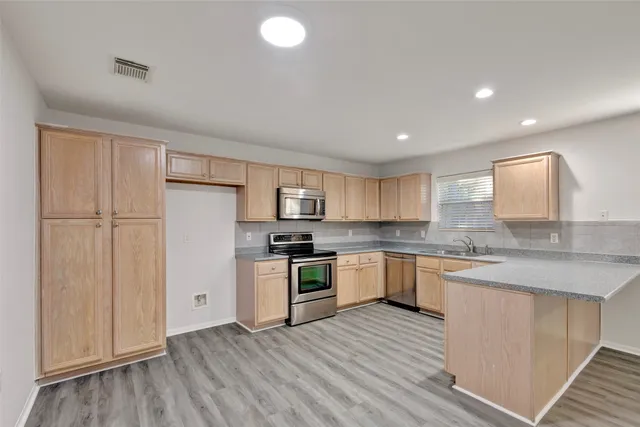 a kitchen with stainless steel appliances granite countertop a sink and stove top oven