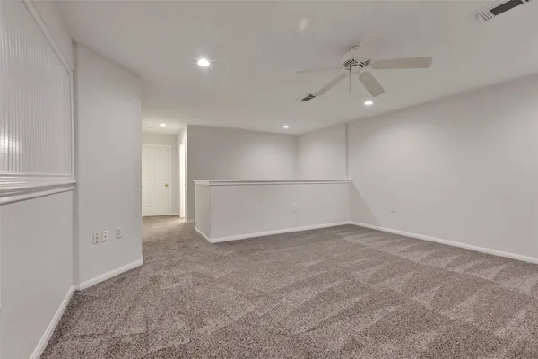 an empty room with an entryway and fan