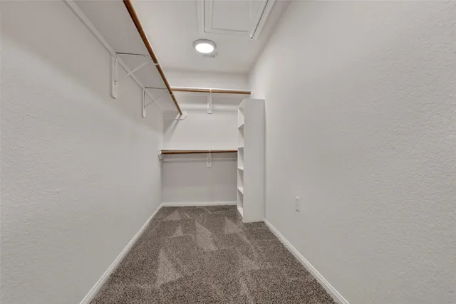 an empty room with windows and ceiling fan