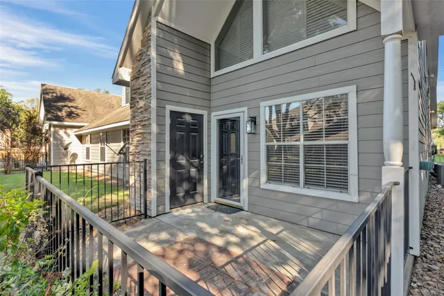 a view of a house with a yard deck and a large tree