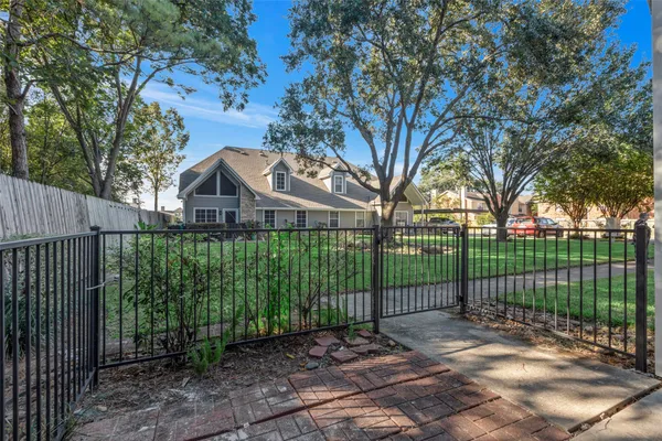 a view of a white house with a big yard and plants