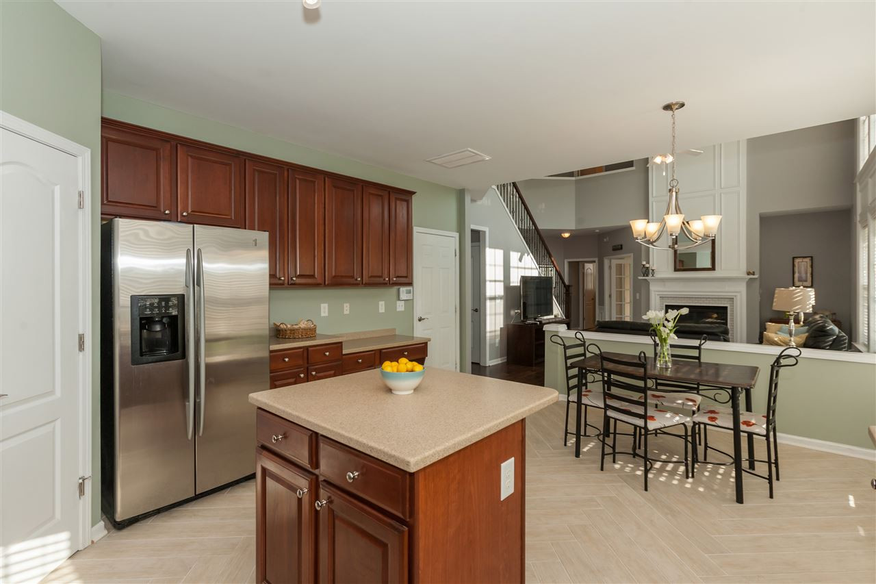 The kitchen features ceramic tile planks laid in a herringbone pattern, a huge island, upgraded cherry cabinets, stainless appliances, and a gigantic pantry. Kitchen