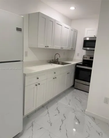 a kitchen with white cabinets and white appliances