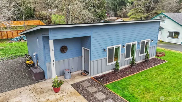 a view of a house with a yard plants and wooden fence