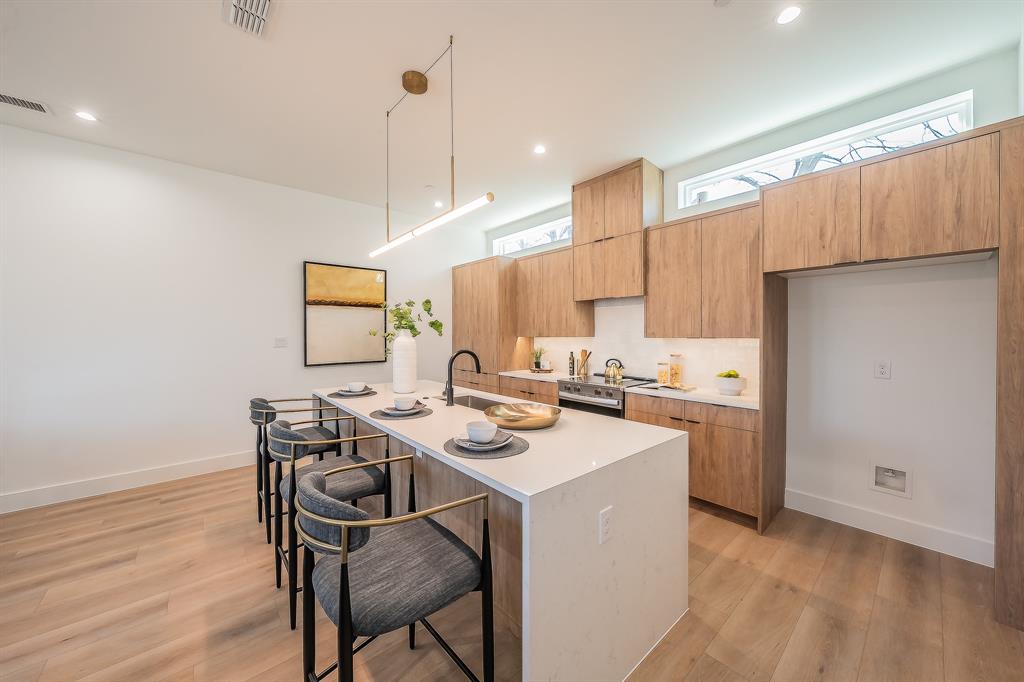 5320 Reiger Avenue, Unit 102 Dallas, TX 75214 - Photo 5 of 33 a kitchen with a sink a stove a refrigerator and wooden floor