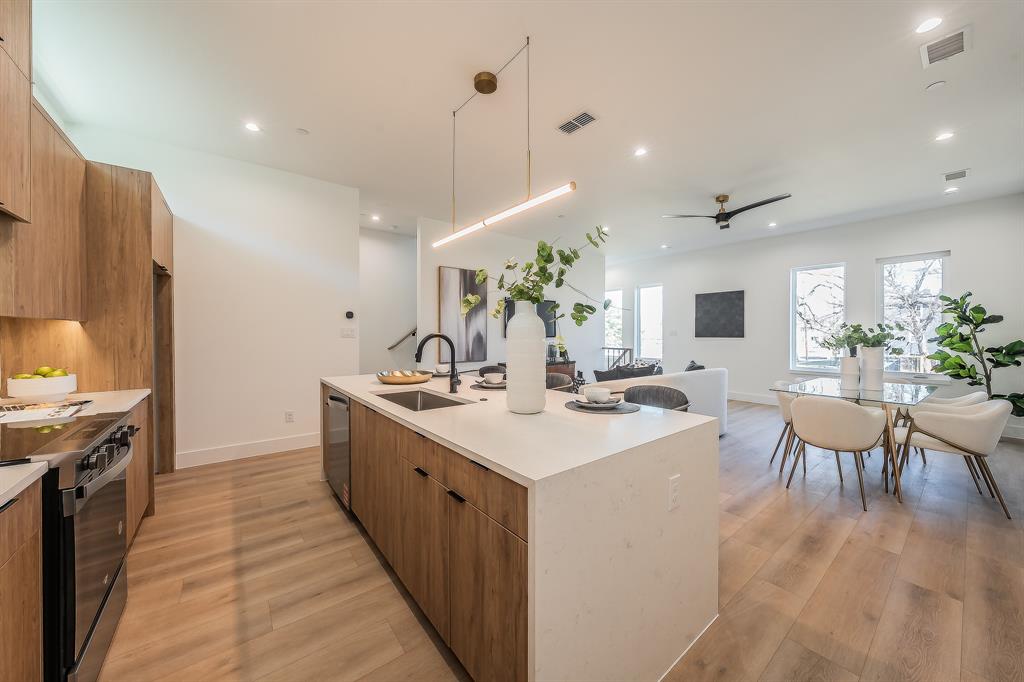 5320 Reiger Avenue, Unit 102 Dallas, TX 75214 - Photo 7 of 33 a large kitchen with kitchen island a sink a stove a dining table and chairs