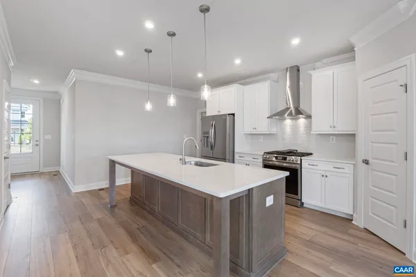 a view of an empty room with wooden floor fireplace and a window