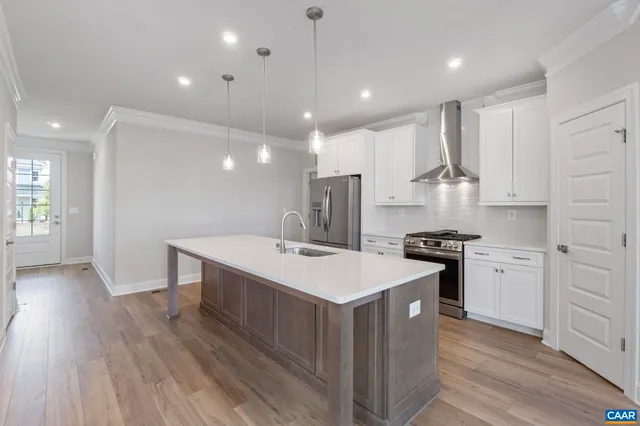 a view of an empty room with wooden floor fireplace and a window