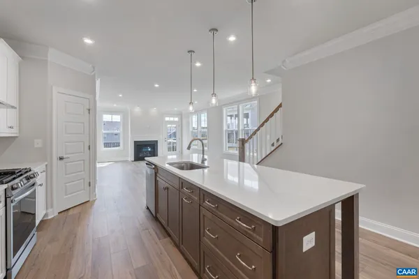 a kitchen with a sink a refrigerator and wooden floor