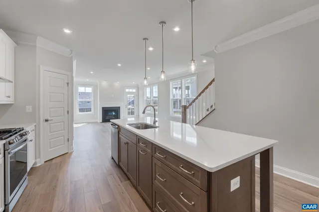 a kitchen with a sink a refrigerator and wooden floor