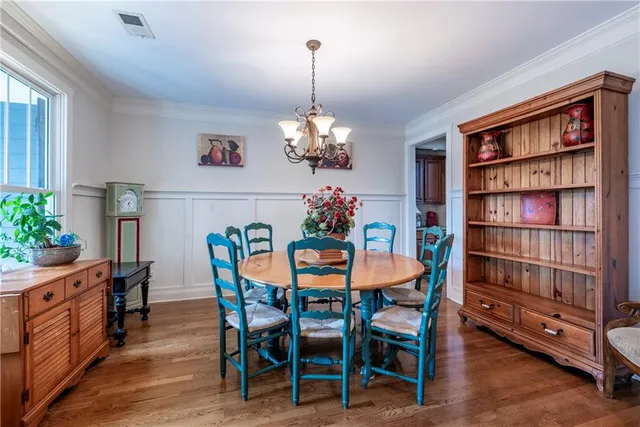 a living room with furniture kitchen view and a wooden floor