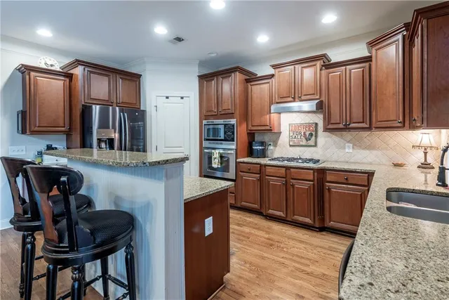 a kitchen with granite countertop a sink stove and cabinets