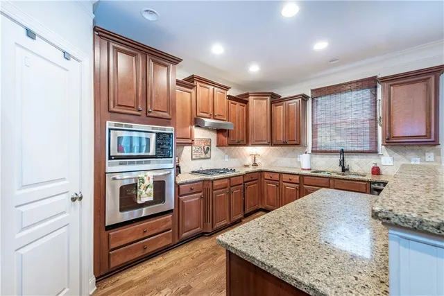 a kitchen with stainless steel appliances granite countertop a sink stove and cabinets