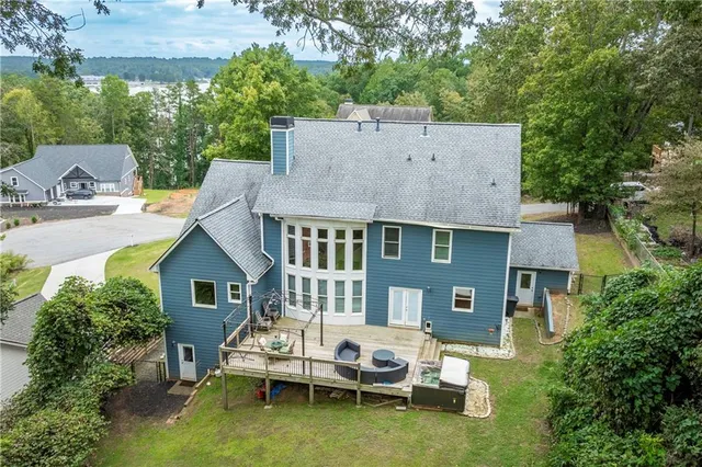 a view of a white house with table and chairs under an umbrella