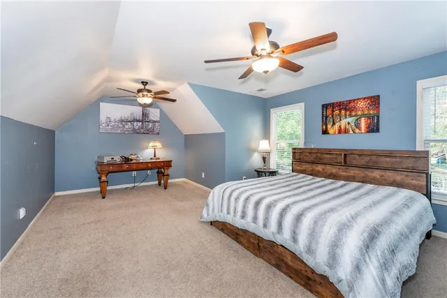 an empty room with wooden floor and a ceiling fan