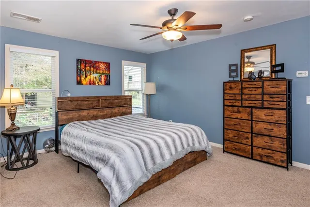 a view of a livingroom with a fireplace a ceiling fan and wooden floor