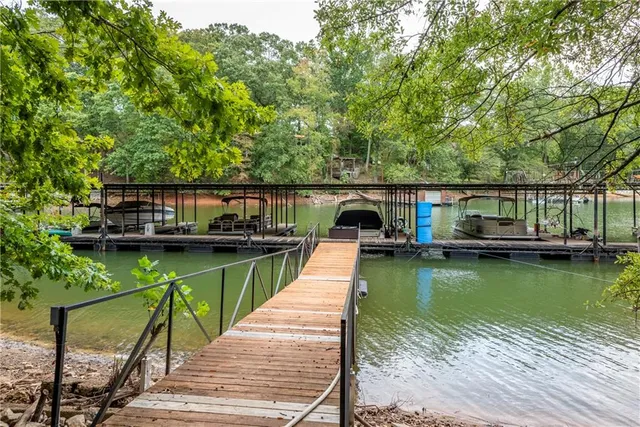 a swimming pool with yard and lake view in back