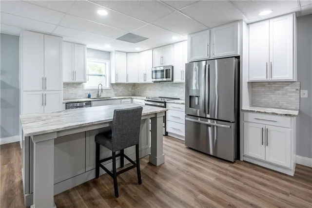 a kitchen with granite countertop a refrigerator stove top oven and sink