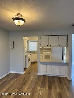 a kitchen with wooden floors and white cabinets