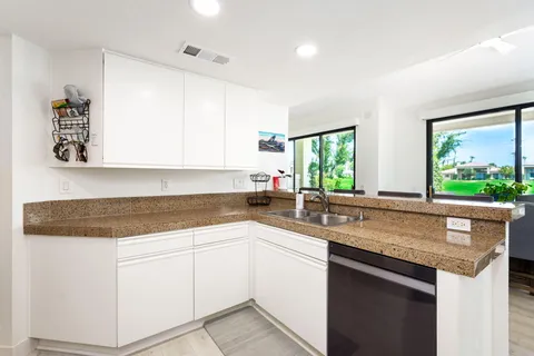 a kitchen with sink a window and cabinets