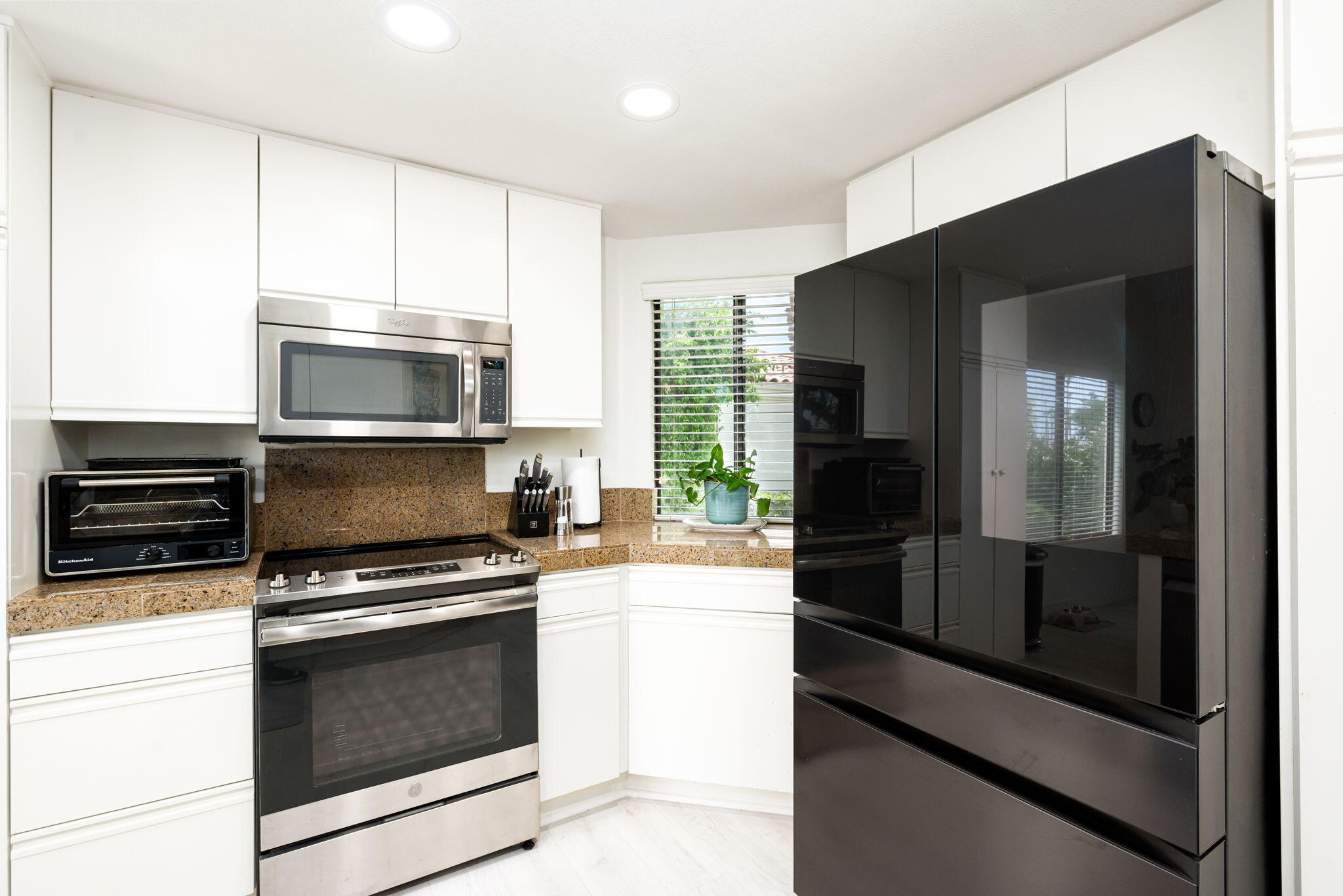 54912 Shoal Creek La Quinta, CA 92253 - Photo 15 of 36 a kitchen with a refrigerator stove and microwave
